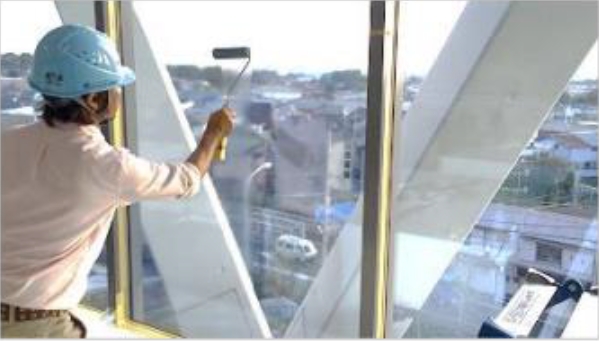 窓ガラスに遮熱塗料ECOアテインを塗布している作業員